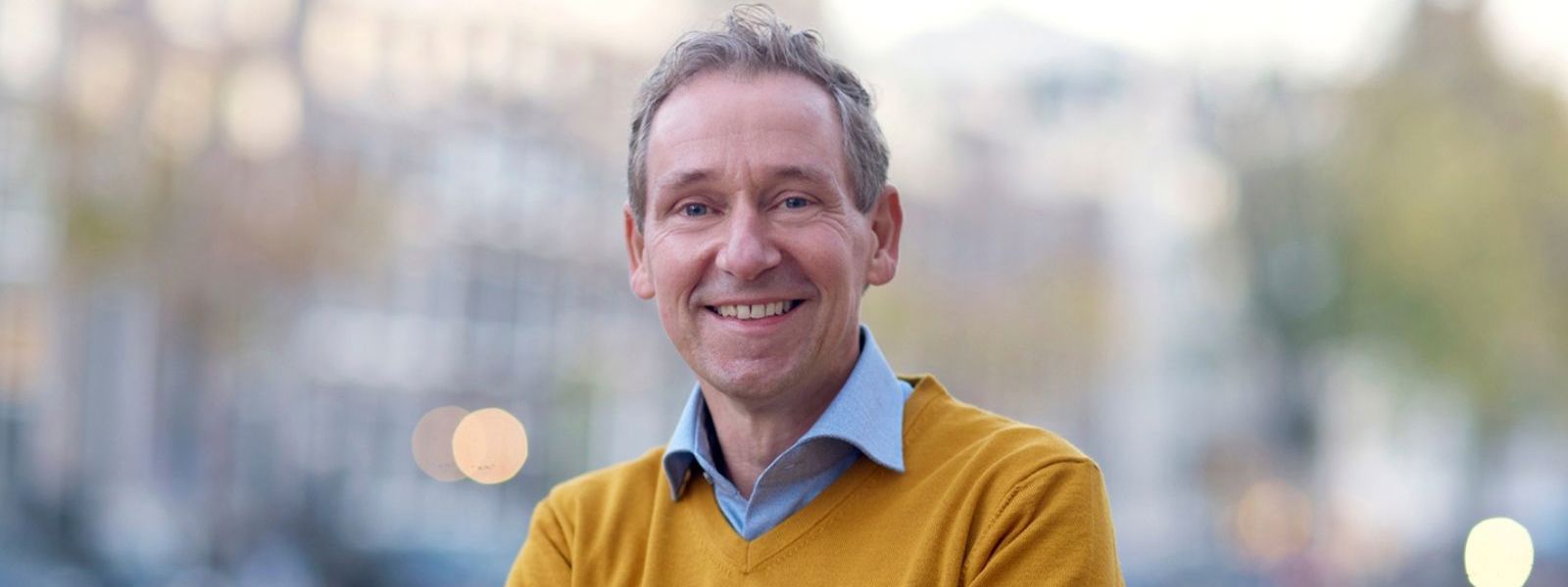 man met armen over elkaar die de kracht van een holistische visie uitstraalt